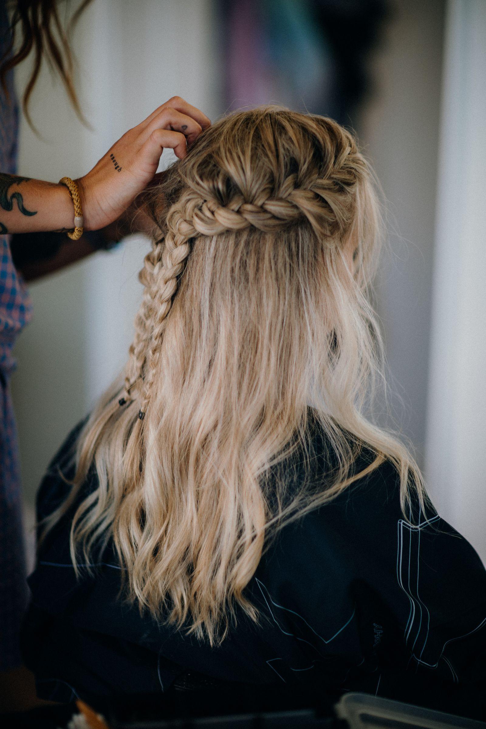 Half-up braided hairstyle being finished on a blonde client, candid styling moment