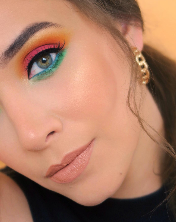 Close-up beauty portrait with vivid multicolour eyeshadow and soft complexion