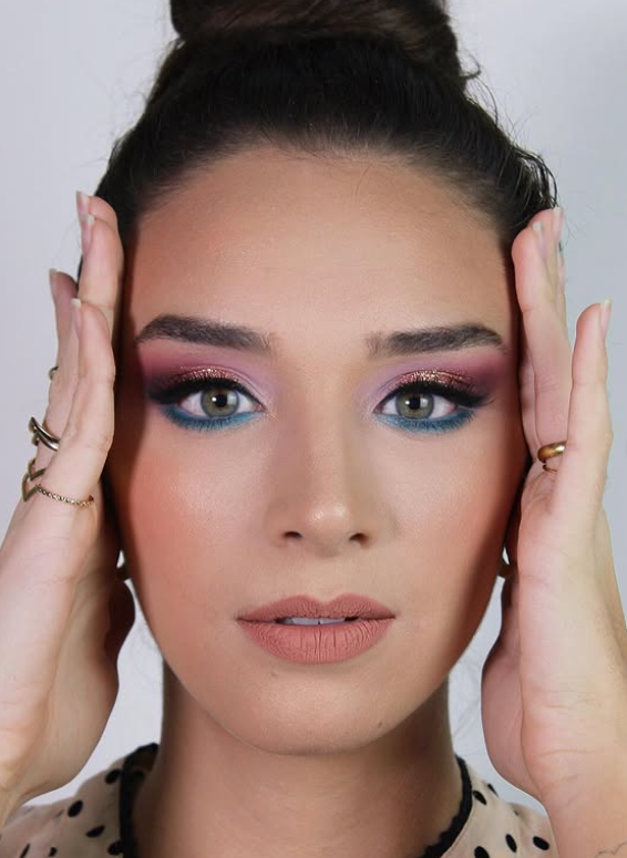 Beauty portrait with pink and gold gradient eyeshadow, teal lower lash line and glossy nude lip