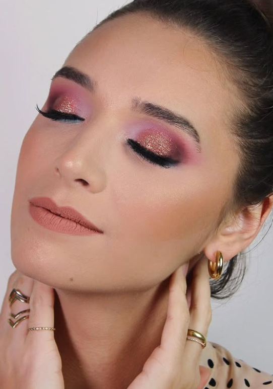 Close-up beauty detail, eyes closed, shimmering pink and gold eyeshadow with a matte mauve lip